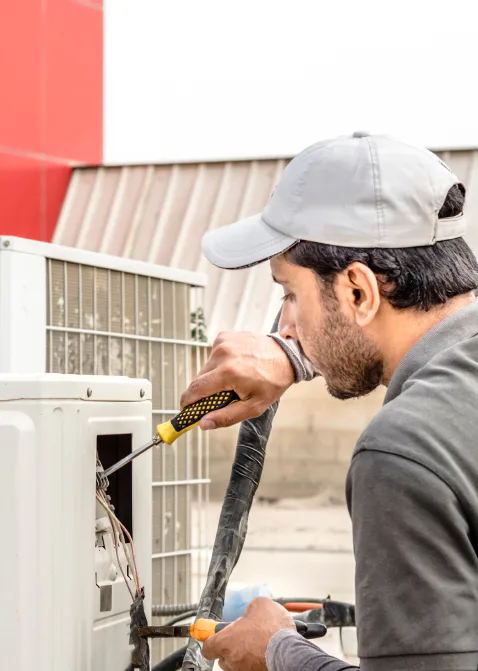hvac technician using a screwdriver during hvac repair goldsboro nc